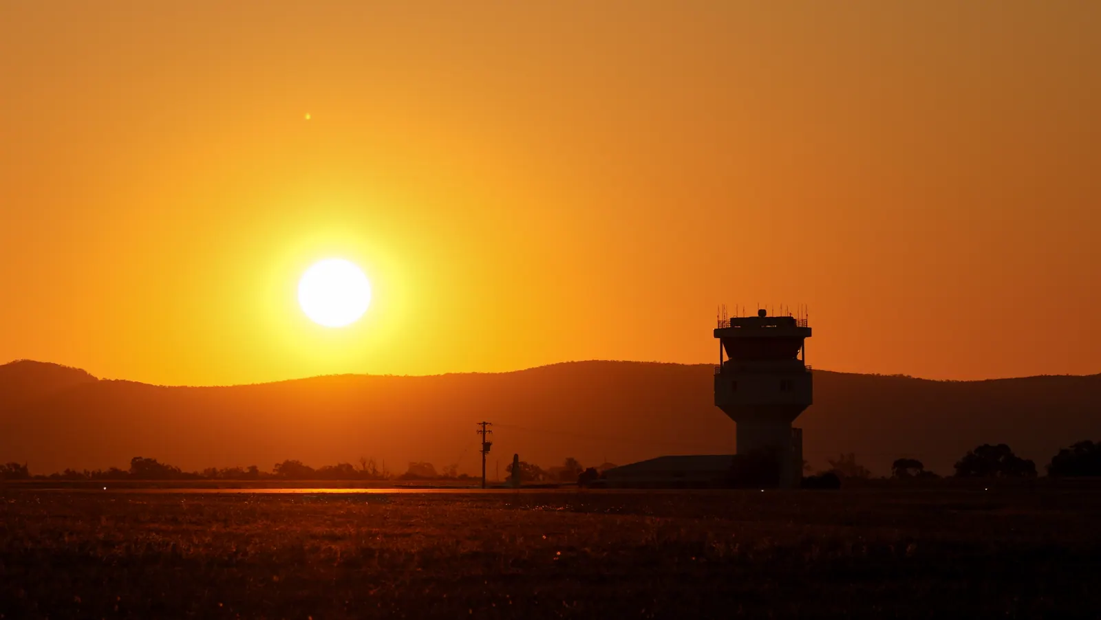 A control tower on the airfield at sunset